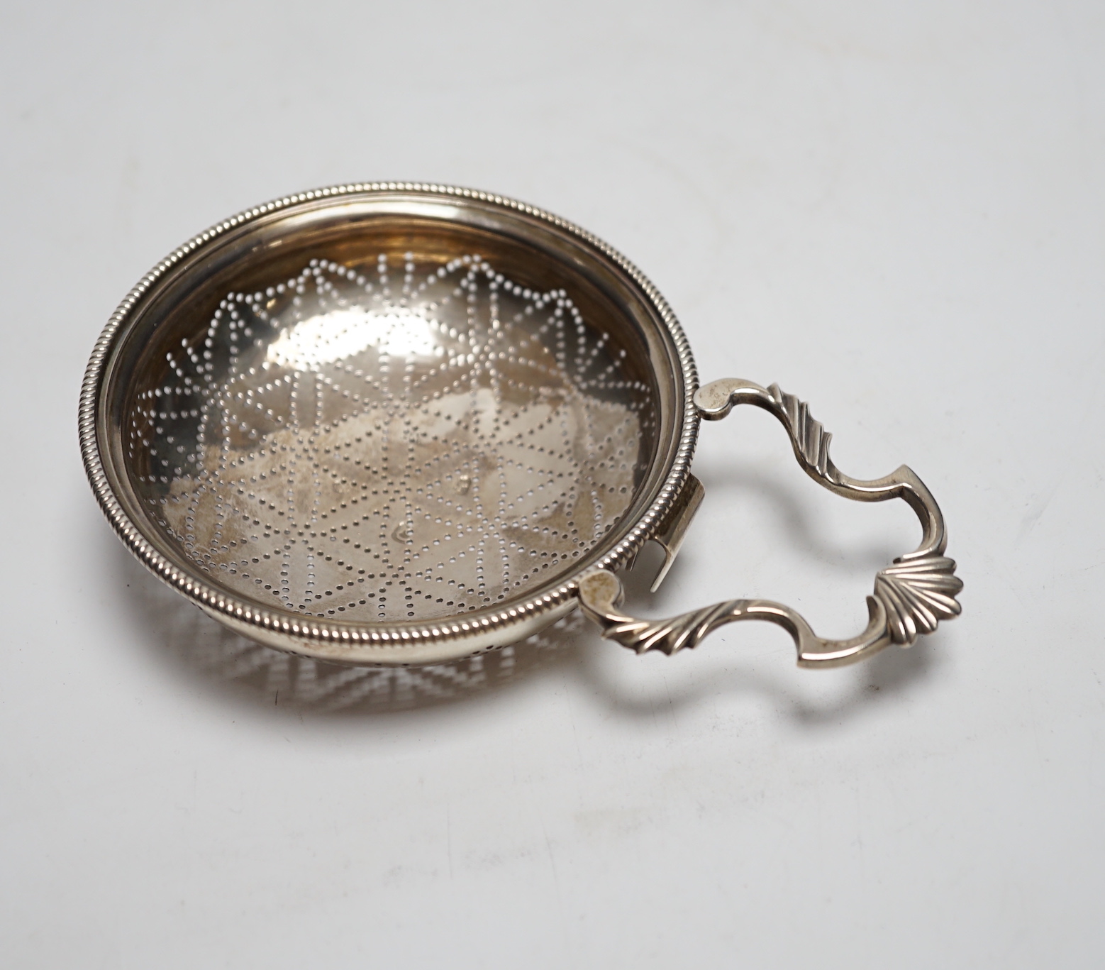 A late George II silver lemon strainer, maker WS?, London, 1759?, 14.7cm.